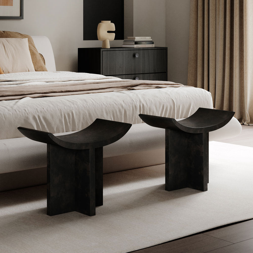 Two Brutus stools in a bedroom setting with a bed and a Tribal Vase on a nightstand.