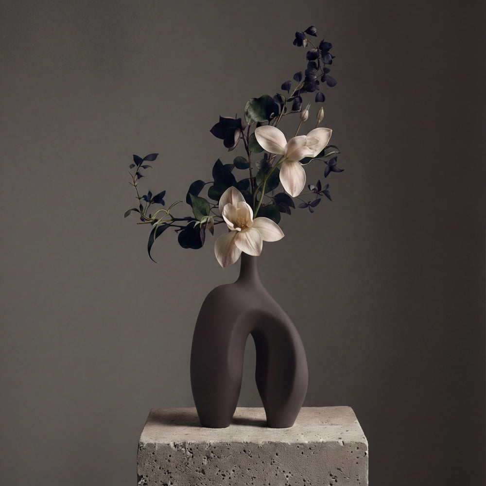 Modern Ni vase with flowers on a concrete block against a dark background