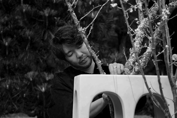 Hikaru Seino arranging branches on a Bow console