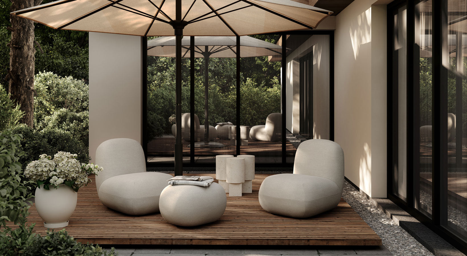 Modern outdoor seating area with Toe chairs chairs and toe ottoman under a large umbrella, surrounded by greenery.
