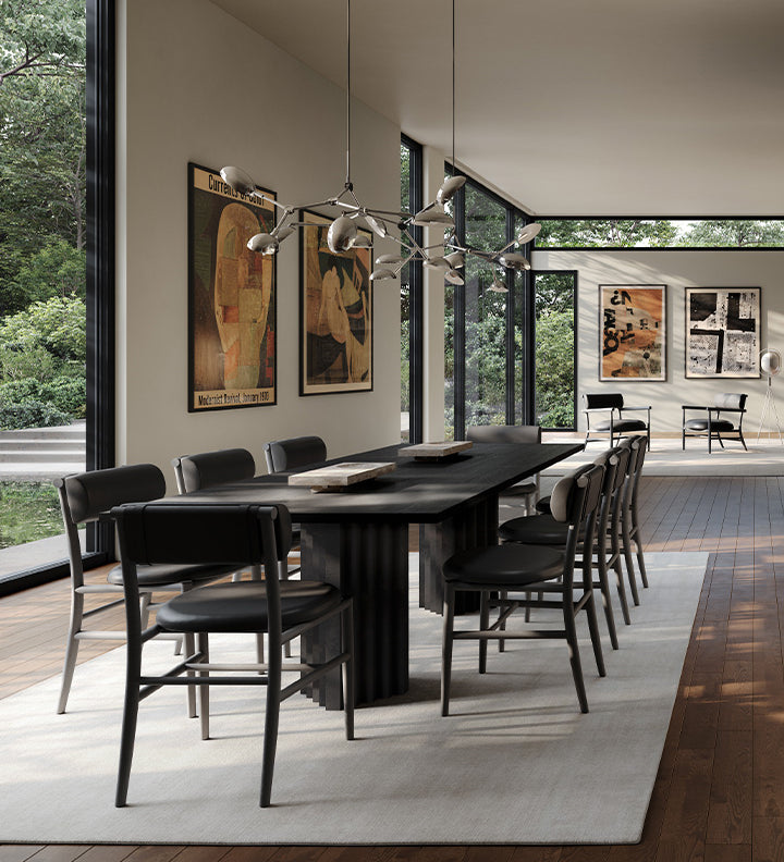 Modern dining room with a long black Arc dining table and Nama dining chairs, and Drop Chandelier in Chrome large windows, and artwork on the walls.