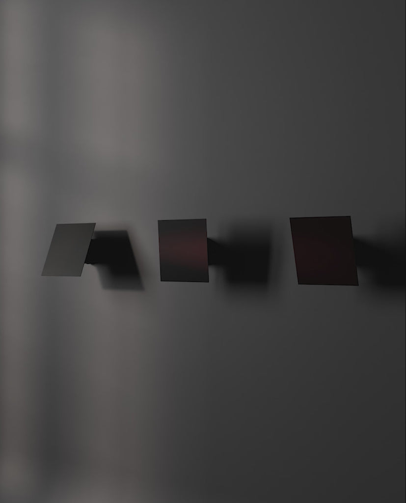 3 directions of Chameleon Wall lamp in Burned black, lit and off.